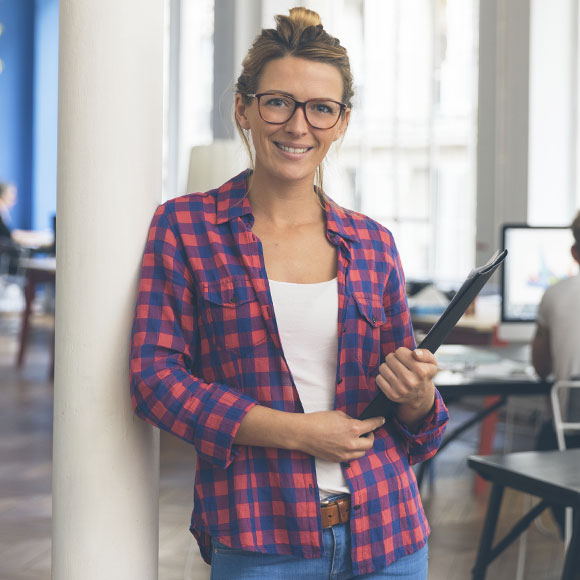 Woman standing in a office: Commercial Property Insurance